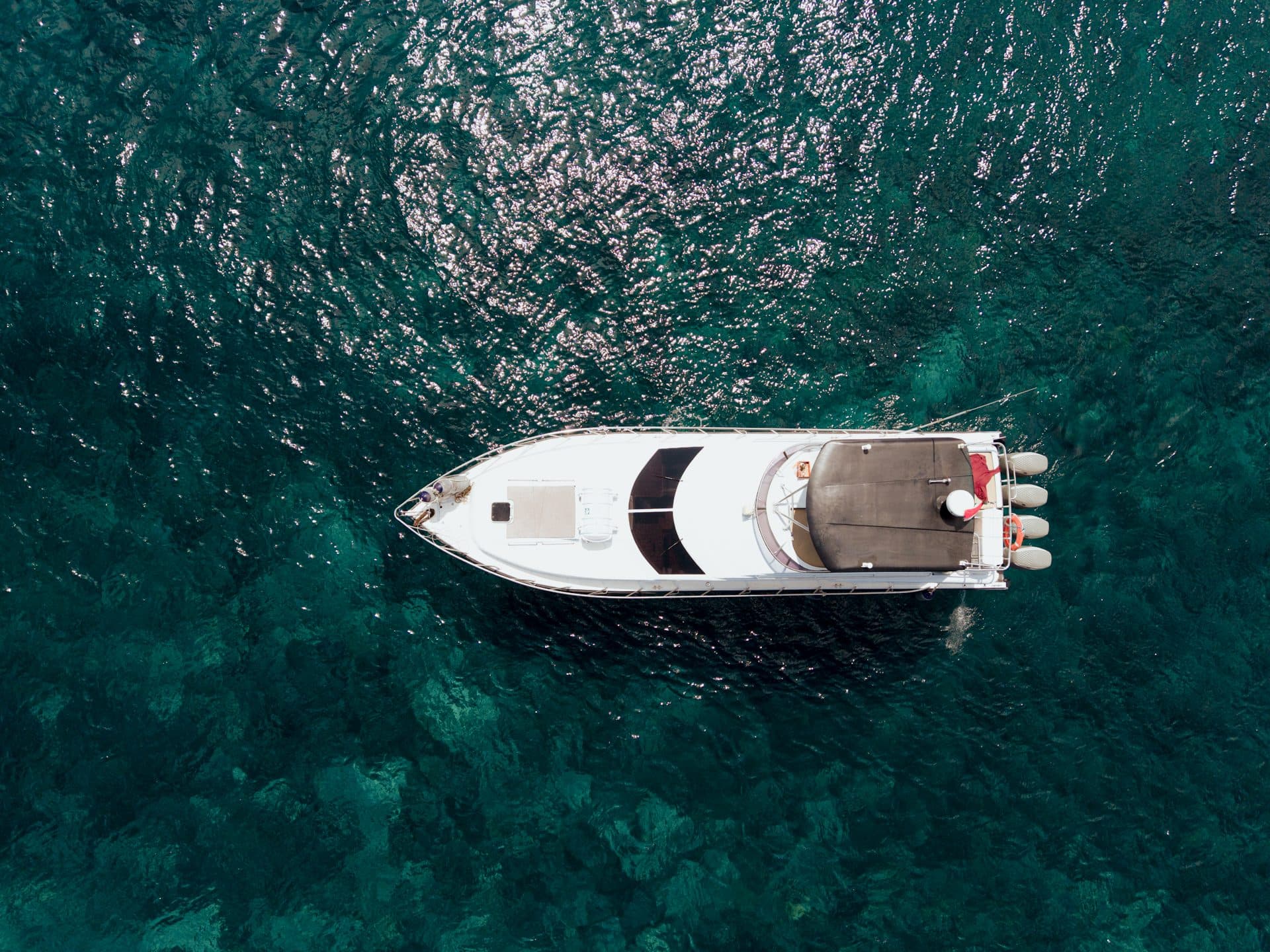 Aerial drone view of a luxury yacht on turquoise water in Bali