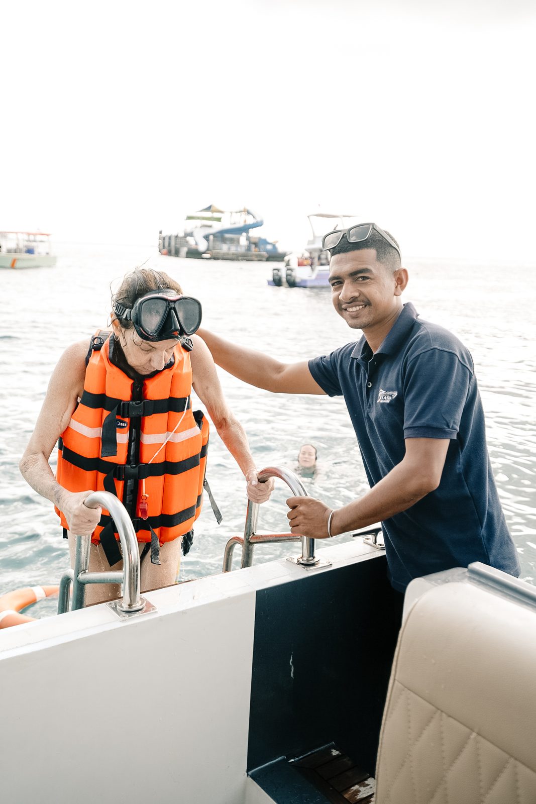 Crew helping a guest with a life jacket aboard the yacht in Bali